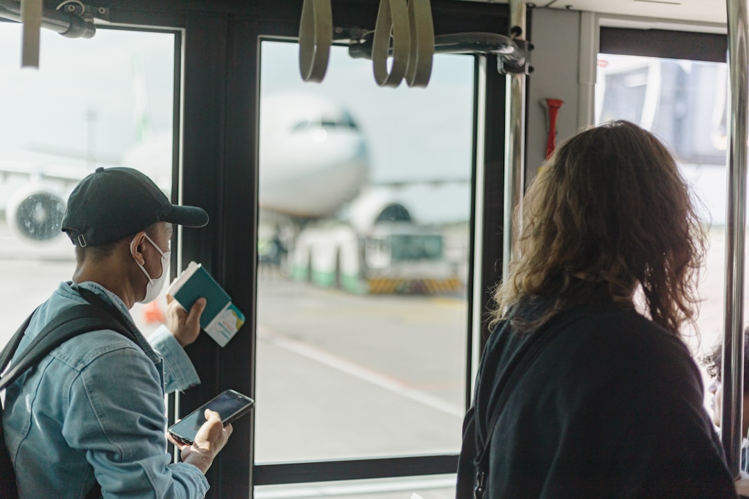 People boarding a bus with airplane visible outside